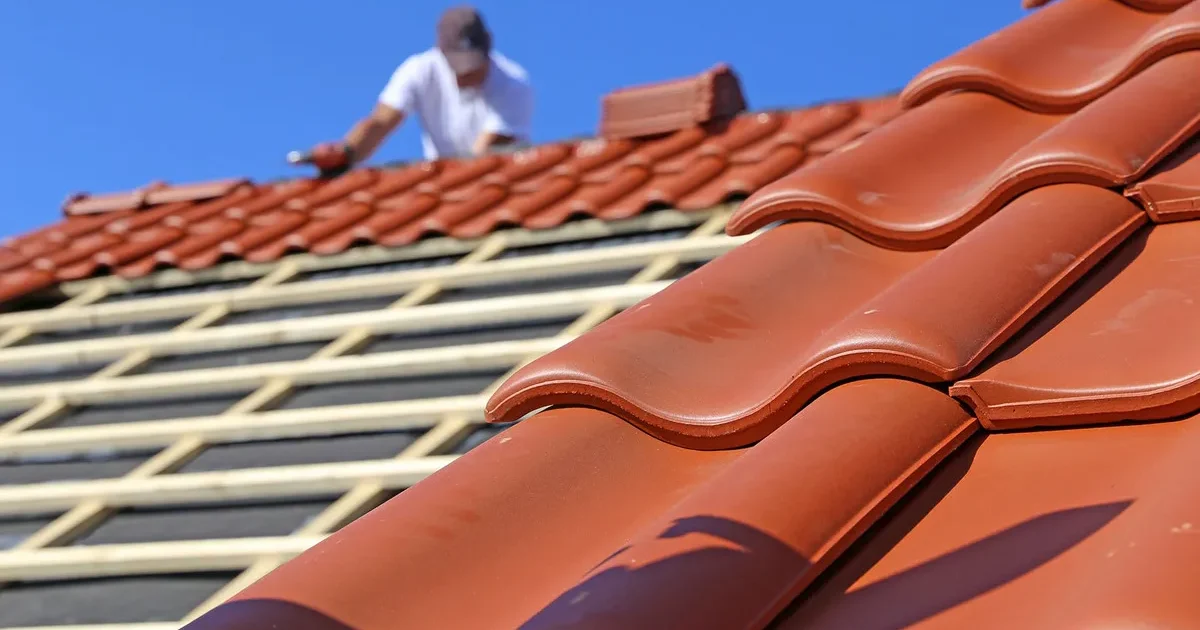 photo d'une toiture ou un professionnel pose les tuiles